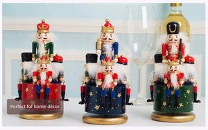 Detailed view of three nutcracker musical boxes with gold stars and wooden base