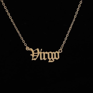Macro shot of Virgo zodiac pendant in gothic font with golden stainless steel link chain