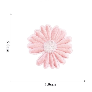 Detail showing pink daisy embroidered patch dimensions on a white background with ruler