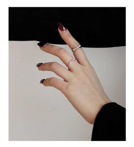 Vista dettagliata di due anelli irregolari a forma di S in argento sterling con finitura