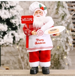 Detail of chef Santa Claus figurine holding a welcome sign and cookies tray for Christmas