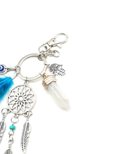Macro view of Hamsa Hand and Dreamcatcher keychain with crystal and blue feather detail