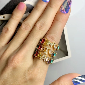 Gold letter M I A rings with colorful heart and rectangle zircon stones on a female hand