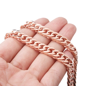 Close-up of 8mm rose gold stainless steel cuban chain link held by hand to show texture