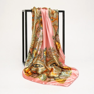 Sciarpa di seta satinata con motivo paisley rosa arancio appesa a una cornice metallica