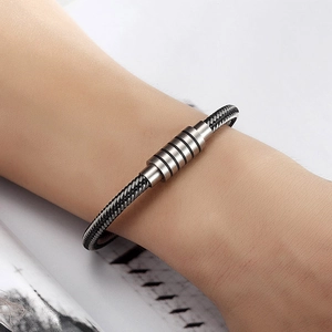 Men's minimalist stainless steel wire bracelet with magnetic clasp on a wrist