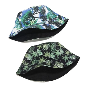 Reversible outdoor bucket hats with tropical floral and palm leaf prints on white background
