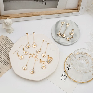 Detailed view of white daisy earrings with gold plating and delicate floral petals