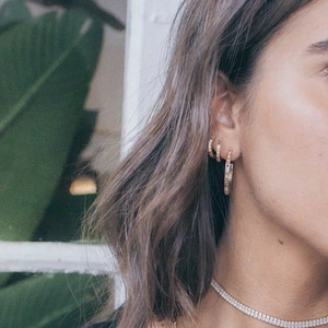 Gold C-shaped hoop earrings set with rainbow cubic zirconia and tennis necklace