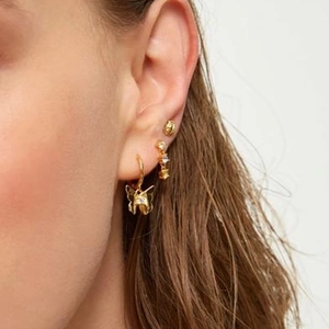 Elegant gold butterfly hoop earrings set with zircons shown on a model's ear