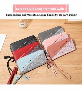 Close-up of long zip wallets with diagonal patchwork design and tassel wristlet detail