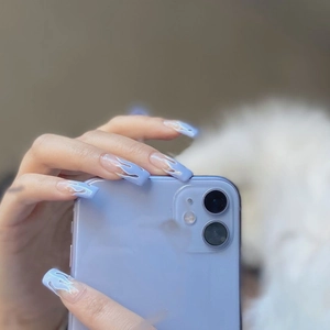 Close-up of light blue flame pattern long coffin press-on nails held with a phone