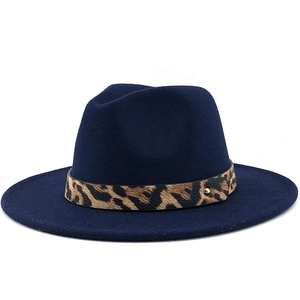 Detail of dark blue fedora hat featuring leopard print band with gold stud accents