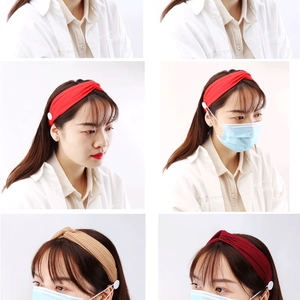 Détail de bandeaux tricotés avec boutons pour masques en couleurs rouge et beige