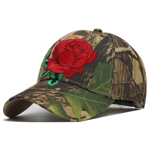 Detailed embroidery of a red rose on a camouflage baseball cap with fine stitching
