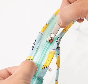 Close-up of light blue zipper detail with lemon pattern on waterproof PVC toiletry bag