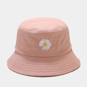 Détail de la broderie de marguerite et des coutures sur un chapeau bob en toile rose