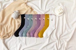 Flat lay of 8-pack ribbed cotton crew socks with embroidered daisy patterns
