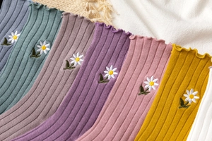 Close-up of cotton crew socks with daisy embroidery and elegant lettuce edge cuffs