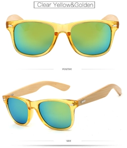 Close-up of clear yellow bamboo sunglasses with golden reflective lenses and wood temples