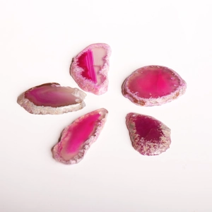 Detailed view of five pink agate slices with natural textures and pre-drilled holes