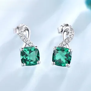Macro view of S925 silver earrings with emerald green stone and twisted cubic zirconia hook