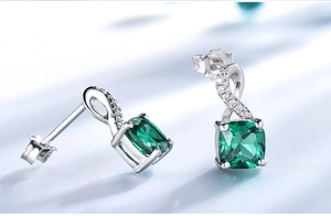 Macro view of S925 sterling silver emerald earrings with fine white zircon accents