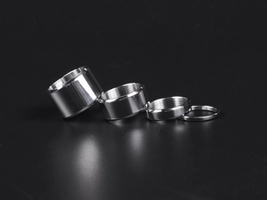 Polished silver stainless steel rings in four different widths against a black background