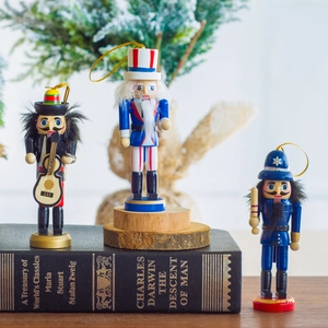 Three 13cm wooden nutcracker ornaments with festive pine and books background
