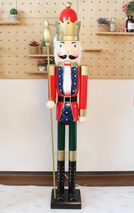 Detail of 180cm wooden nutcracker king doll in red jacket and green pants on black base
