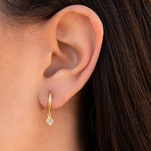 Goldene geometrische Rautenohrringe mit Zirkonia, elegant am Model präsentiert