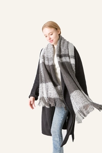 Detail of grey and white plaid scarf with fringe edge texture and soft warm material