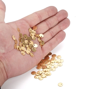 Close-up of gold stainless steel round disc charms with holes for DIY jewelry making