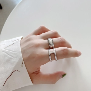 Close-up of a minimalist 925 sterling silver H-shaped ring set worn on a finger