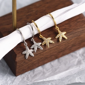 Detailed view of starfish earrings in gold and silver finish with sparkling zircons
