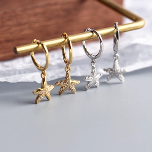 Macro detail of starfish earrings with inlaid rhinestones in gold and silver finishes