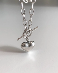 Macro shot of silver heart pendant featuring a unique T-bar toggle clasp and O-chain link