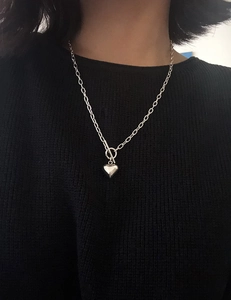 Detail of S925 sterling silver heart necklace with OT toggle clasp on black fabric