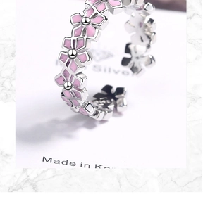 Detailed macro view of silver flower ring with pink resin petals and open band design