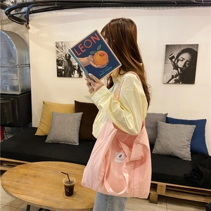 Pink minimalist canvas tote bag styled with casual outfit in an industrial setting