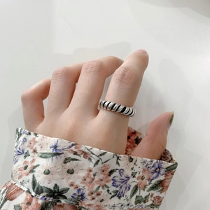 Detail of minimalist 925 sterling silver twist ring with vintage oxidized finish on finger