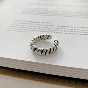 Macro shot of 925 silver twisted ring with vintage oxidized finish on book pages