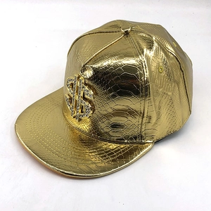 Dettaglio del cappello hip-hop dorato con trama a coccodrillo e segno del dollaro strass