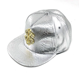 Dettaglio del cappellino in pelle serpente argento con logo dollaro dorato e strass