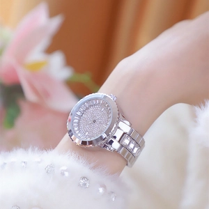 Close-up of luxury silver women's watch with crystals on a wrist with faux fur