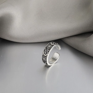 Macro view of vintage silver feather ring with embossed sun and moon celestial motifs
