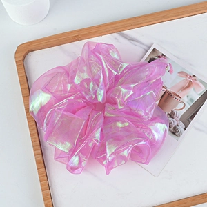 Macro detail of iridescent organza scrunchie with shimmer texture and ruffles