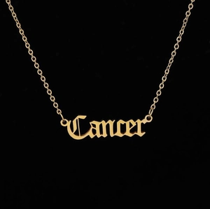 Macro detail of gold stainless steel necklace with Gothic Cancer zodiac pendant