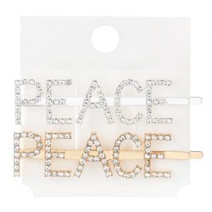 Macro view of gold and silver PEACE letter hair clips with sparkling rhinestone inlay