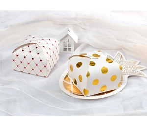 Close-up of square gift boxes with red heart lattice and gold polka dot foil patterns